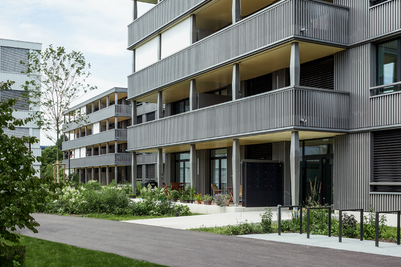 Die Holzverkleidung folgt der Form der Balkone.