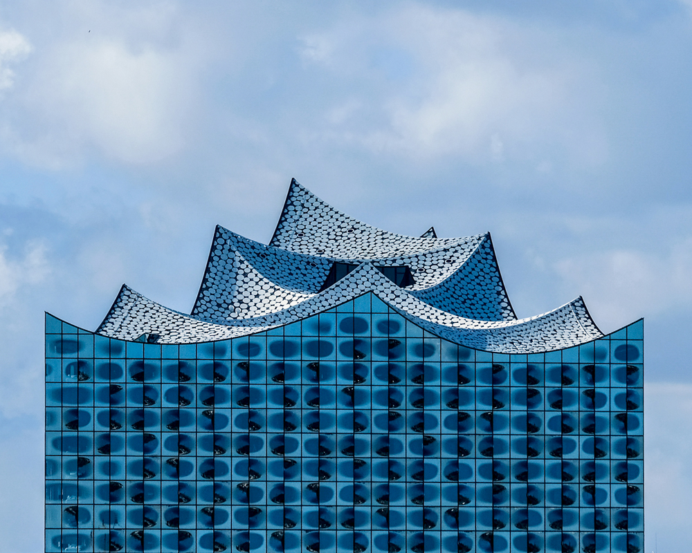 Die gebogenen Dachflächen der Hamburger Elbphilharmonie streben gen Himmel. Die grossen runden Metallteller variieren das Paillettenmotiv, das auch im Innern des Baus an verschiedenen Stellen auftaucht.