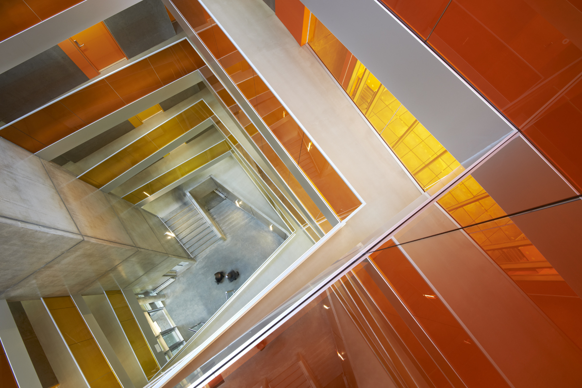Im Atrium regeln umlaufende Galerien, deren Wände von unten nach oben von Gelb nach Orange und schliesslich nach Rot wechseln, den Zugang zu den studentischen Appartements.