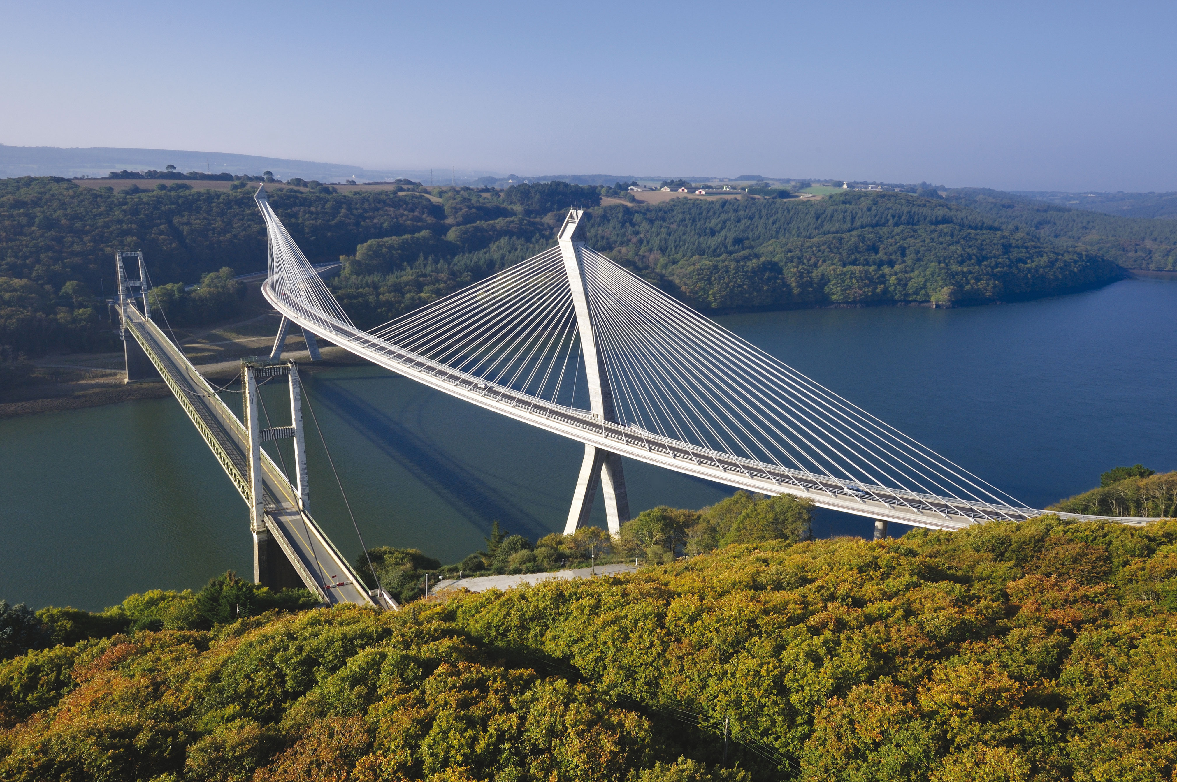 A gauche, l’ancien pont suspendu, aujourd’hui détruit ; à droite, le nouveau pont à haubans