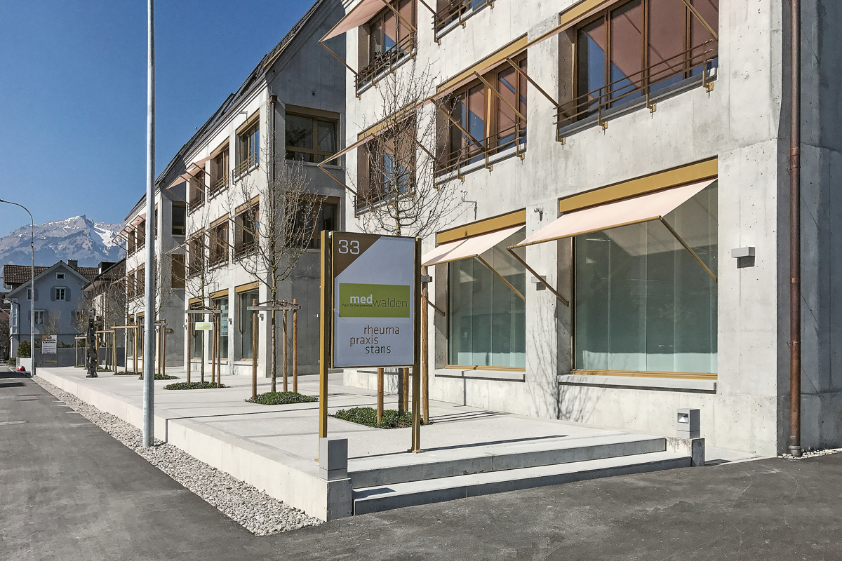 Objektschutz an einer neuen Überbauung im Zentrum von Stans NW: Die erhöhte Kante des Vorplatzes und die offenen Zufahrten am Gebäude vorbei leiten allfälliges Hochwasser in den hinteren Bereich und verhindern das Einströmen in die Untergeschosse. Architektur: plus architekten, Stans.