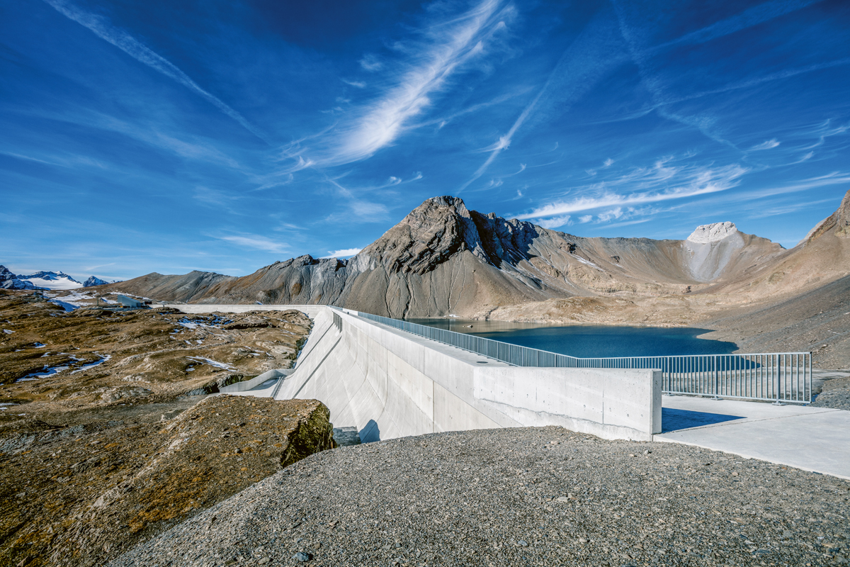 Staumauer Muttsee mit Hochwasserentlastungsanlage (Bildmitte) und dem Muttsee vor seinem Aufstau. Blick nach Westen.