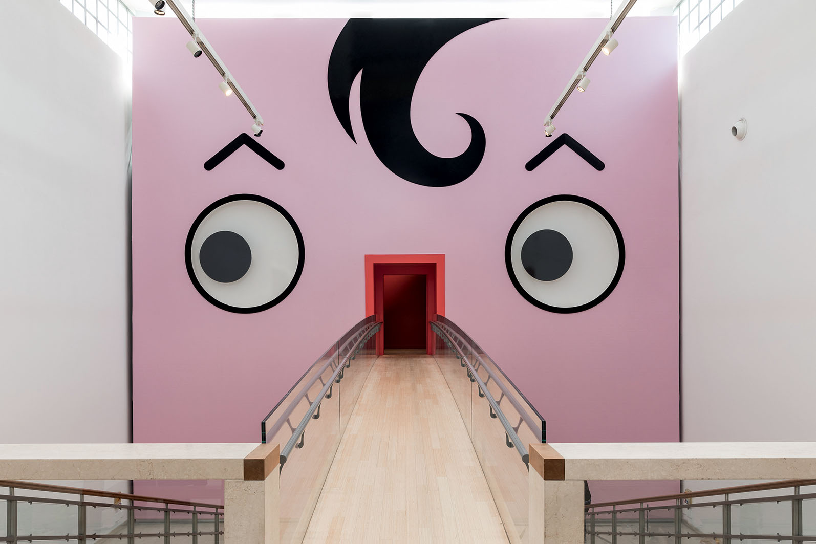 L’ingresso alla mostra attraverso il ponte in legno disegnato da Michele De Lucchi che conduce – passando per la faccia di Quadratino – dentro al Triennale Design Museum.