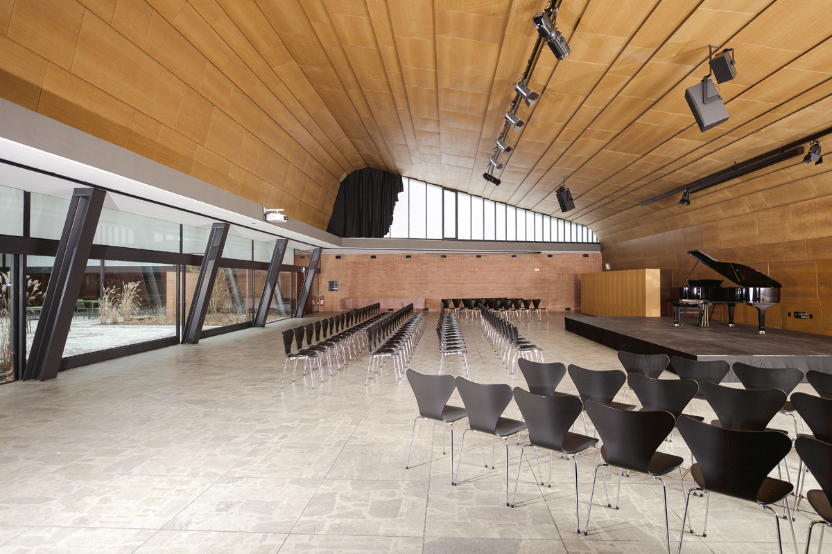 Der Saal im Farelhaus bietet Raum für Veranstaltungen. Beeindruckend sind die expressiv geneigte Decke und die Öffnung zum Hof.