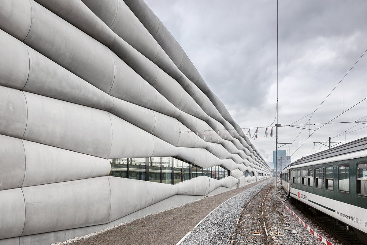 Die 420 m lange Fassade aus Glasfaserbeton der Serviceanlage Herdern flankiert das Gleisfeld vor der Einfahrt in den Zürcher Hauptbahnhof.
