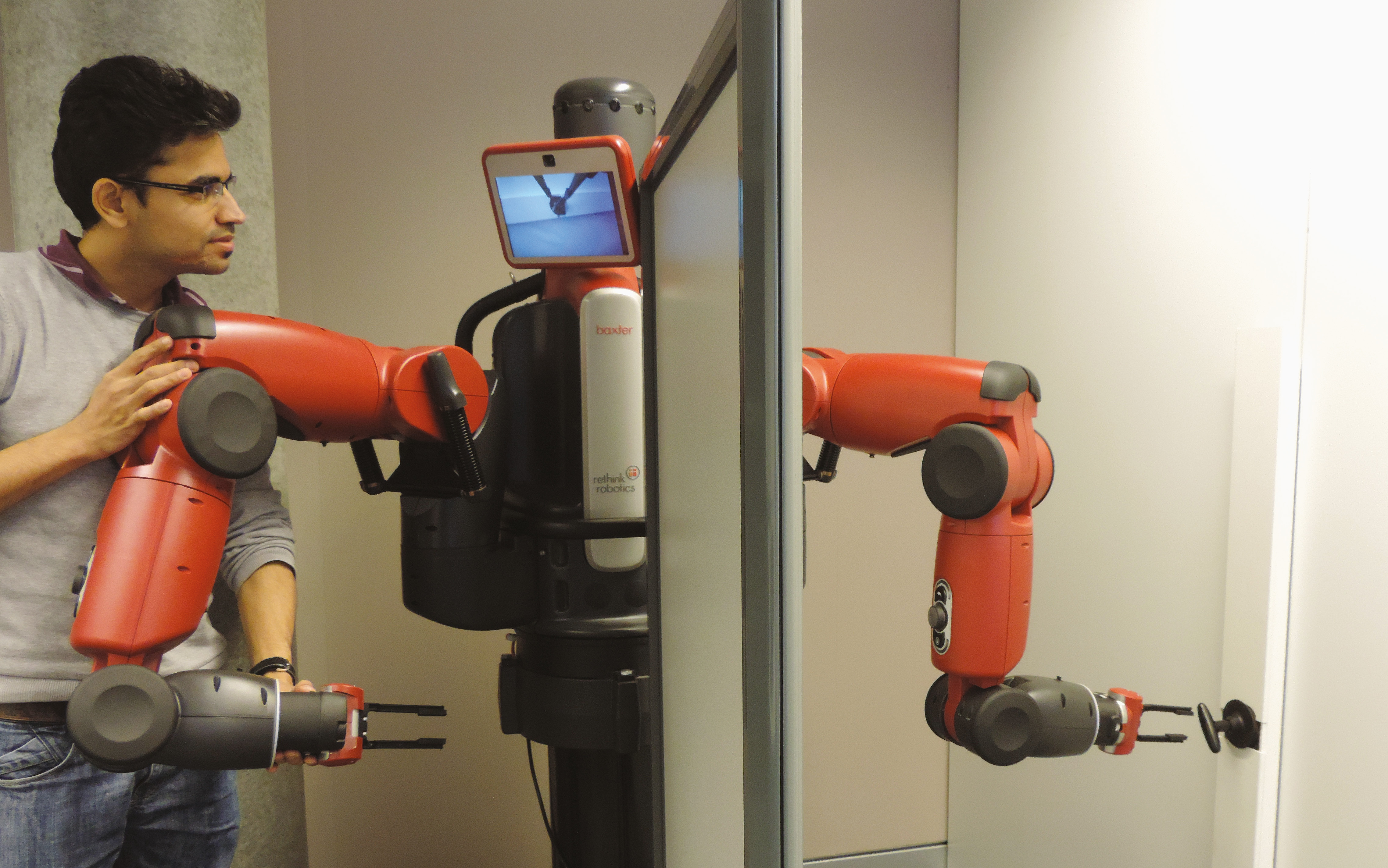 Guidé par un chercheur de l’Idiap, le robot Baxter apprend à tourner une poignée de porte.