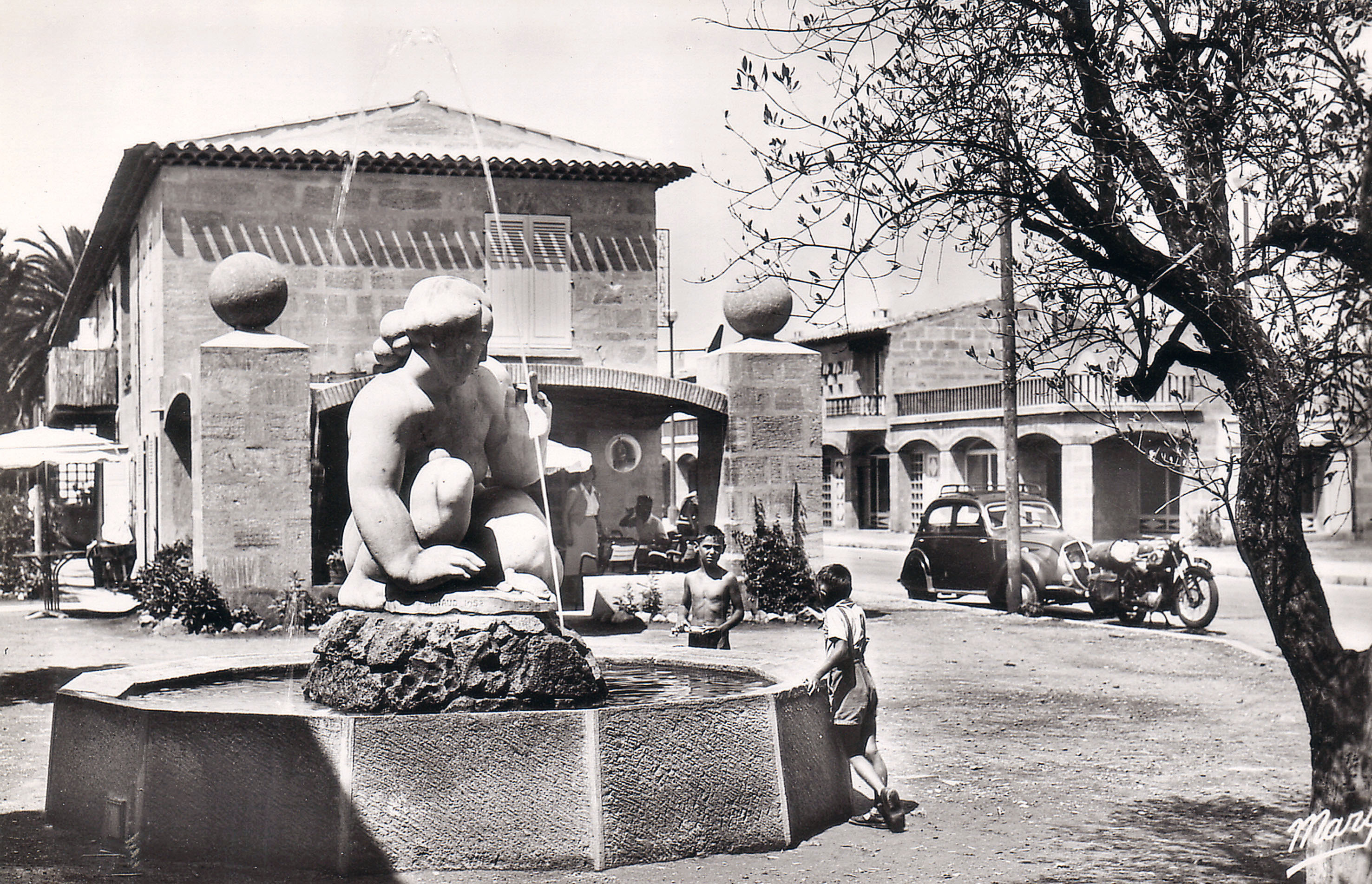 La place Jean Lurçat dans les années 1960 et « La Naïade accroupie » du sculpteur Louis Arnaud, devant le bar des Sablettes et son auvent arqué en briques. Aujourd’hui, le bar a investi l’auvent en le refermant par une véranda.
