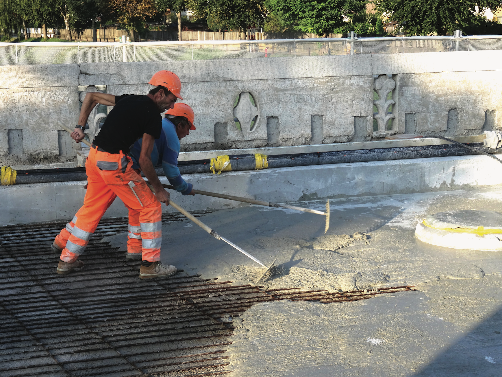 Mise en place du BFUP avec du matériel simple. A l’arrière-plan, on aperçoit les parements préparés pour la remise en état.