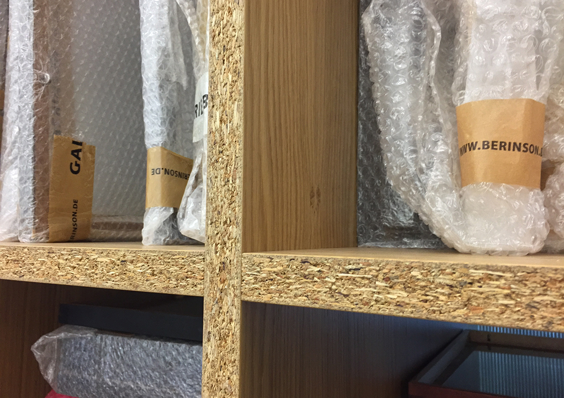 Das Regal, das als Bilderlager dient, setzt sich durch das grobe Material bewusst von der umgebenden Architektur ab.