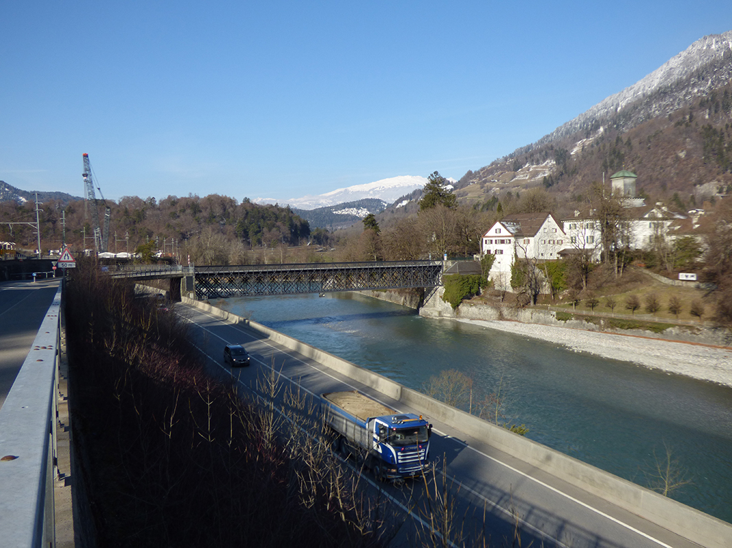 Schloss Reichenau oberhalb des Rheins. Im Vordergrund die A13, links die Bahnlinie. Der Standort des Krans verrät die Baustelle der neuen Hinterrheinbrücke.