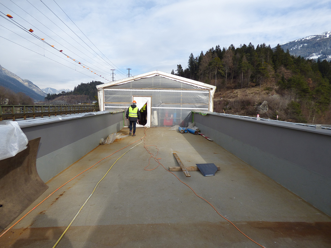 Bereits eingesetzter Trogquerschnitt. Die längste Spannweite der Brücke beträgt 63 m. Die Gleise werden auf einem Schotterbett versetzt.
