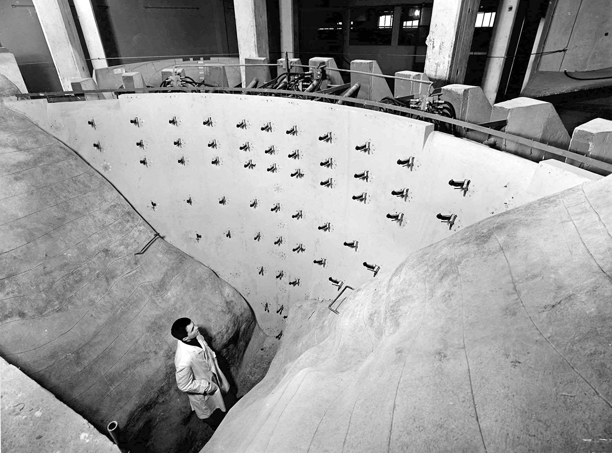 Modell der Contra-Bogenstaumauer im Massstab 1 : 66.6. Dahinter die Widerlager der Hydraulikpressen, die die Belastung der Mauer simulieren.
