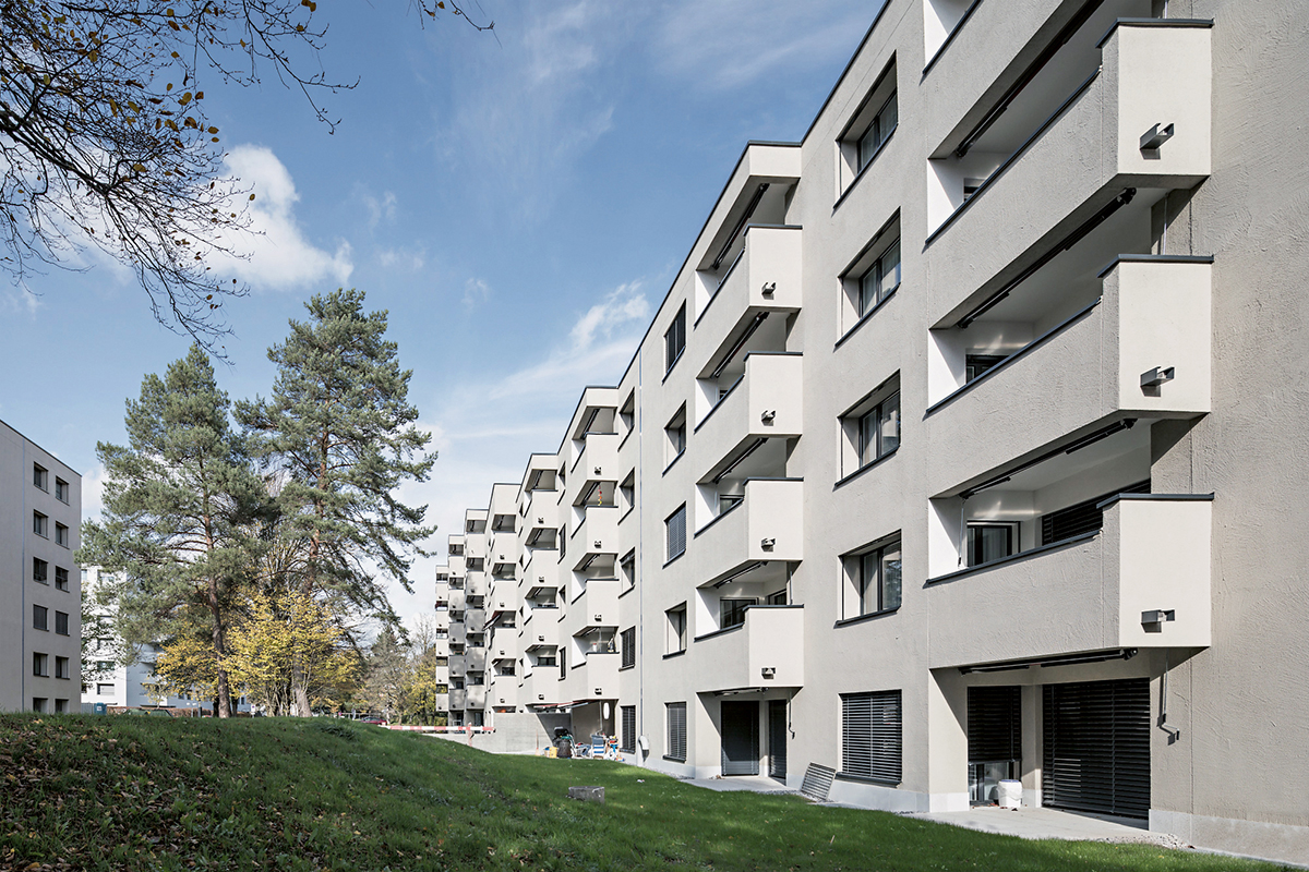 Ansicht des Innenhofs und der rückseitigen Fassaden der Wohnsiedlung Paradies nach der Erneuerung. Die Originalstruktur mit den abgestuften Balkonen blieb trotz zusätzlicher Aussendämmung gewahrt.