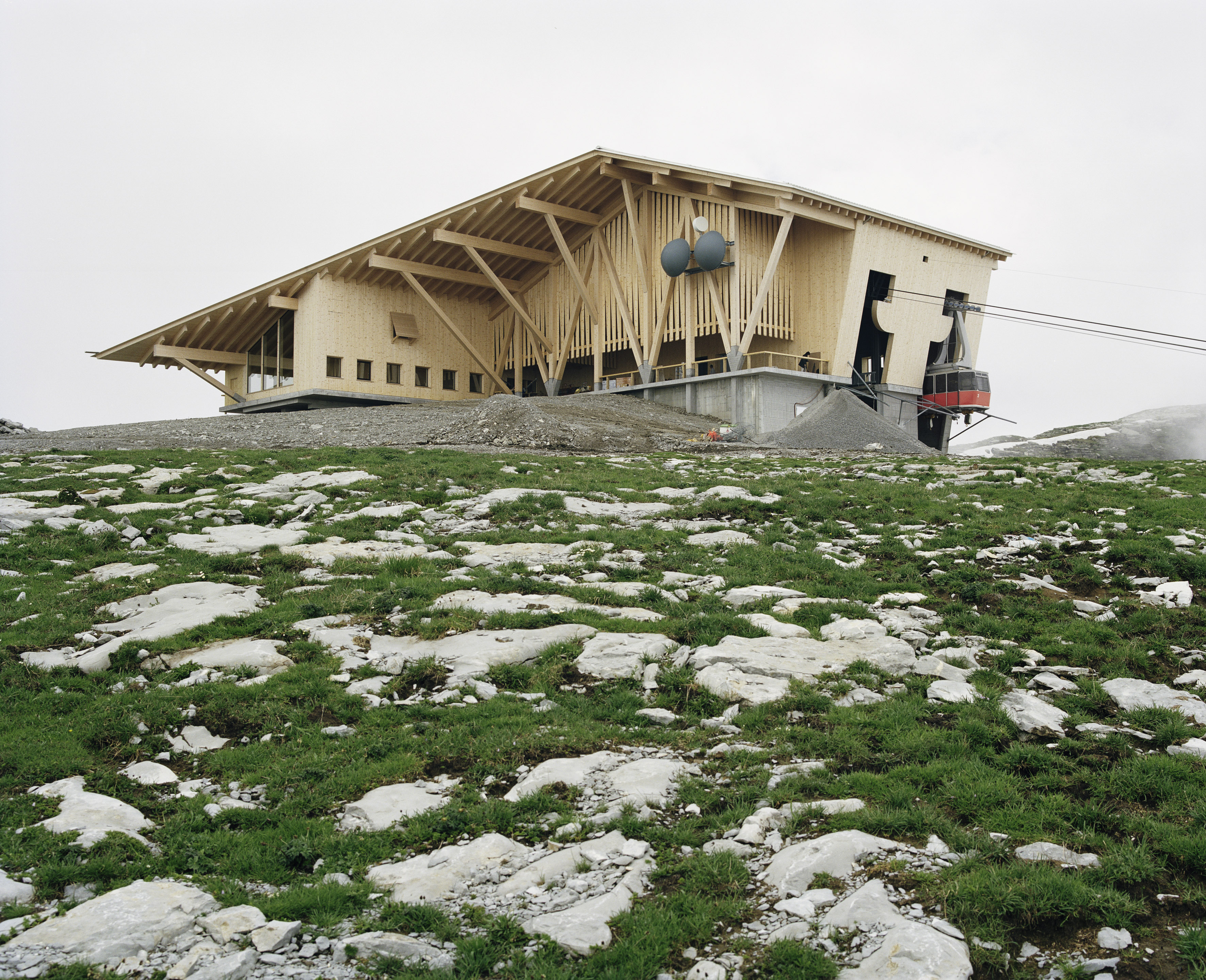 OR National: Gare d’arrivée du téléphérique de Chäserrugg, Unterwasser SG, 2015 L'idée maîtresse des architectes Herzog &amp; de Meuron était de réunir sous un seul toit le nouveau restaurant à l'ancienne gare. Bien plus que de répondre aux seules contraintes, les architectes ont su imprimer une expression, qui donne à voir à la fois une grange, un chalet ou une station d’altitude, avec au-dessus, un toit qui unifie l’ensemble. Le travail de charpente est audacieux: colossaux sur-plombs, pans