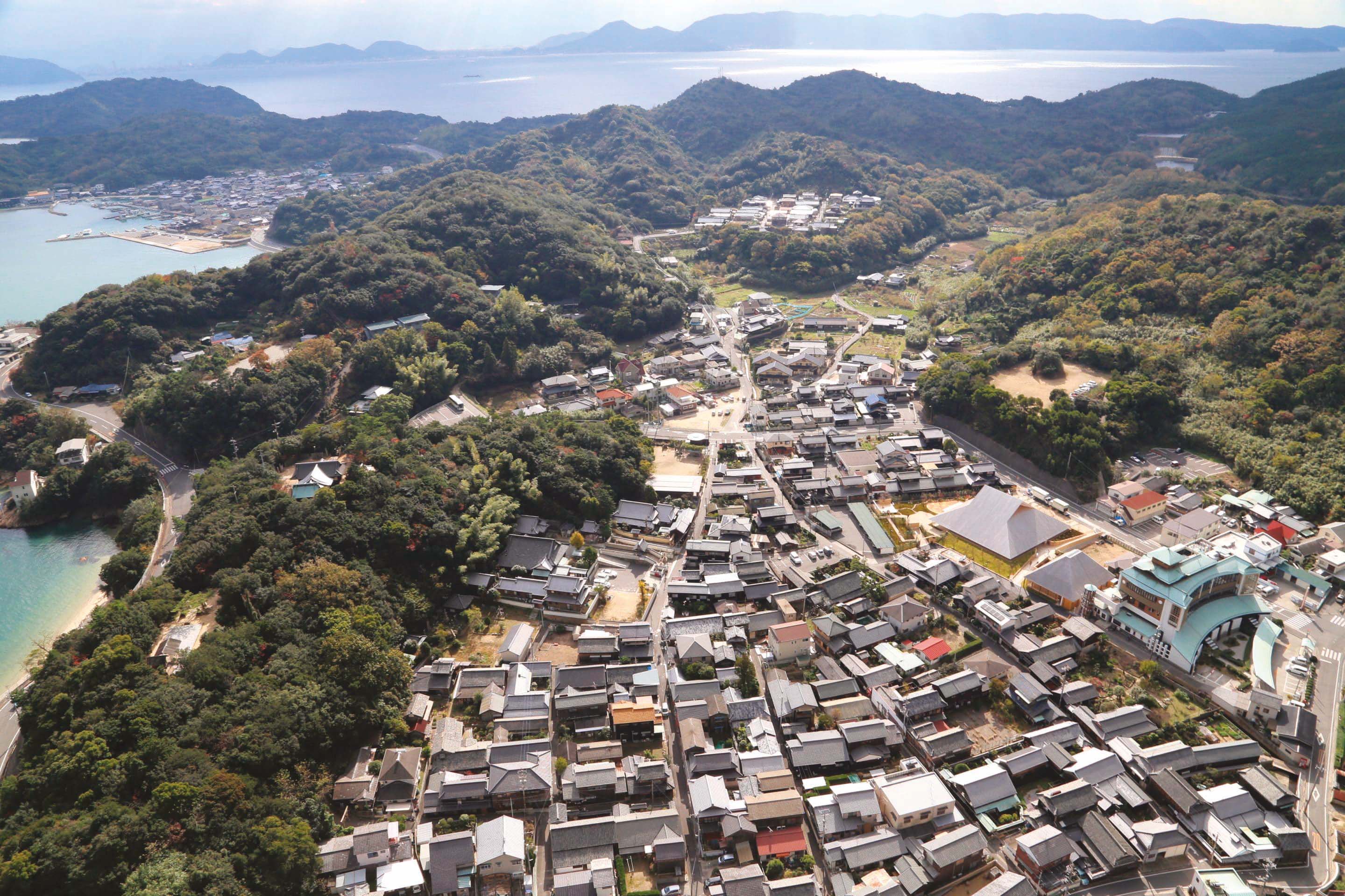 La grande halle de Naoshima à Honmura. L’implantation s’inscrit sobrement dans un tissu bâti marqué par des « matériaux mobiles » de l’île, selon Hiroshi Sambuichi : les cours d’eau et le vent.