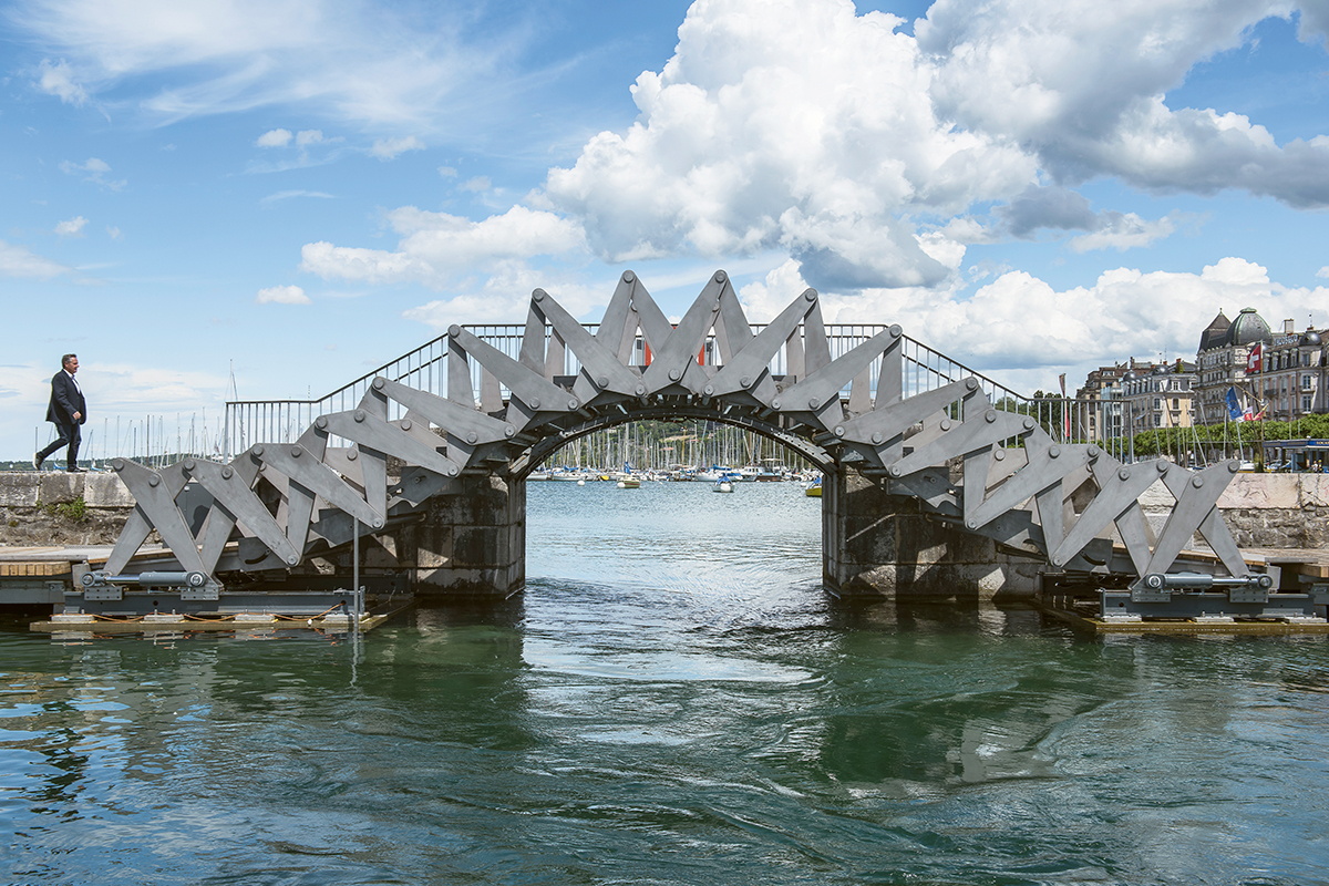 Passerelle mobile du Jet d’eau de Genève – Preisträger Prix Acier 2018 Mit der hydraulisch anheb- und absenkbaren Brücke an der Promenade des Genfersees wird diese auch für Personen mit eingeschränkter Mobilität zugänglich und bleibt trotzdem für kleine Boote passierbar. Die Planer von Ingeni und MID Architecture entwickelten das Tragwerk als einen Scherenmechanismus, den acht Kolben an den Extremitäten auseinander schieben. Dadurch hebt sich die Brücke in der Mitte um ca. 2 m an und verlänge