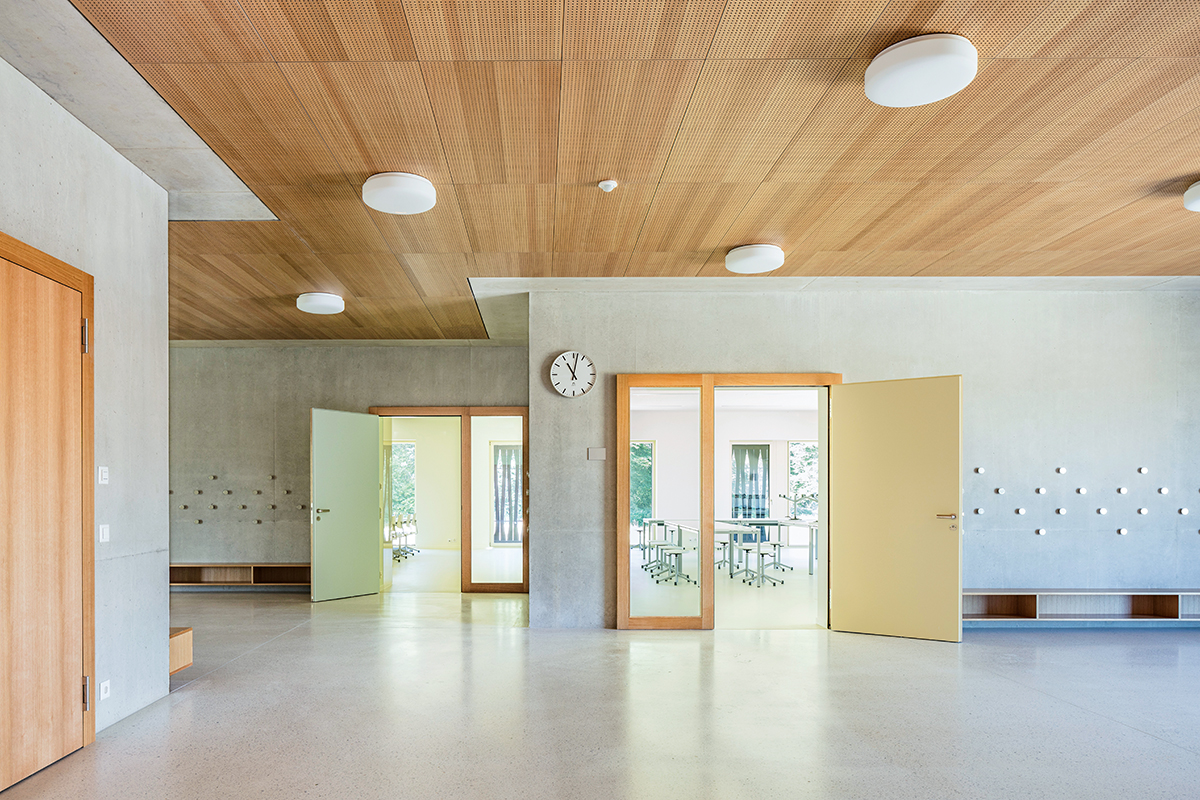 Schulzentrum Chavully in Granges-Paccot: Pastellfarbene Klassenräume und die Erschliessungshallen in Holz, Terrazzo und Sichtbeton bilden eine harmonische Einheit.