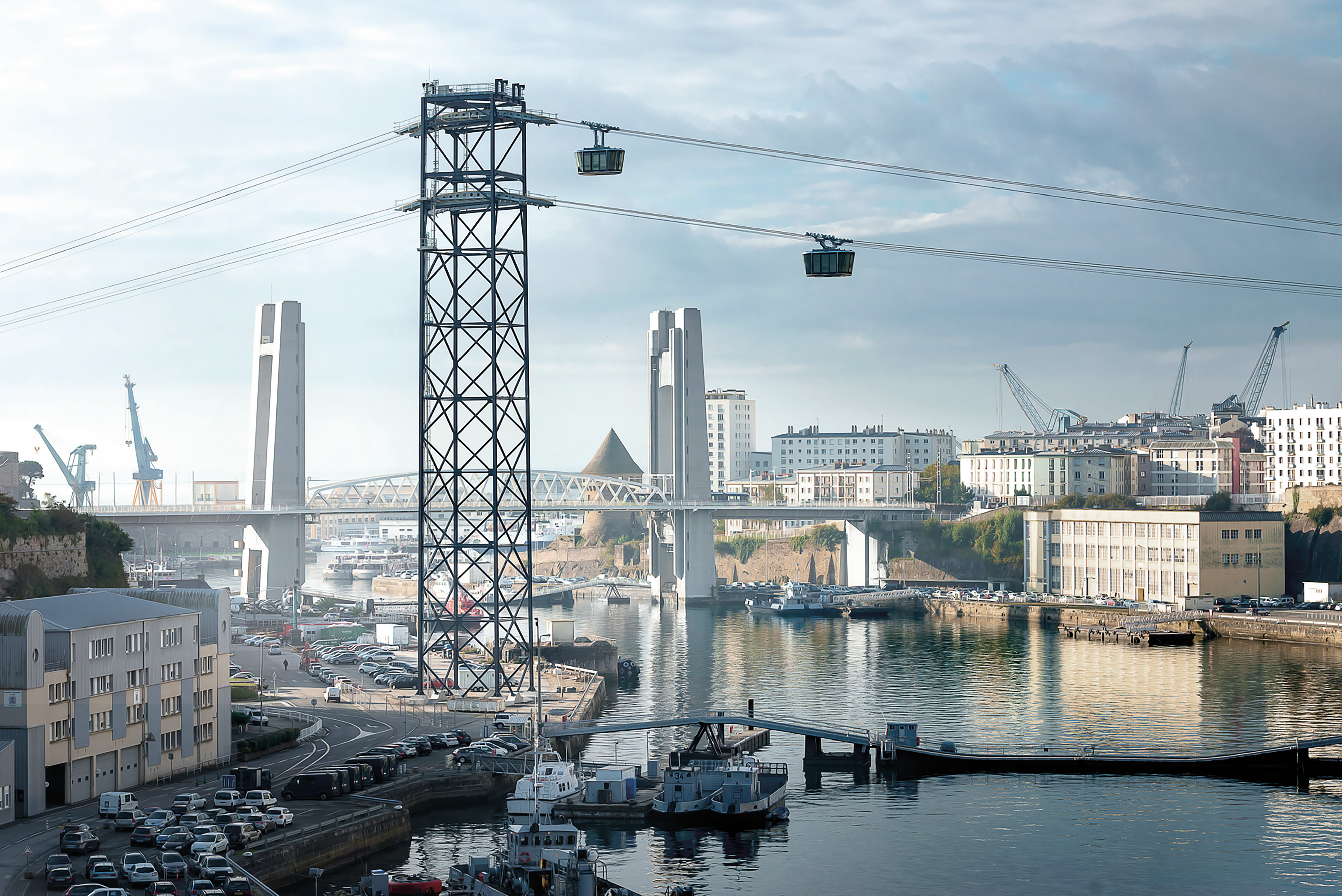 Le téléphérique de Brest se situe en amont du pont de Recouvrance, derrière lequel on aperçoit l’un des rares bâtiments de la préfecture du Finistère ayant survécu aux bombardements alliés de la Seconde Guerre mondiale. De par sa forme proche des grues navales, le pylône haut de plus de 80 m s’intègre dans le site de l’arsenal de Brest.