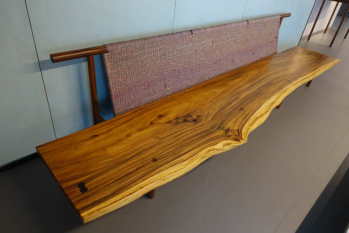 Feste Sitzbank mit einer von Hand gehobelten massiven Holzplatte. Diese Holzplatten werden als Rohstoff zur Feinverarbeitung angeboten – hier sind sie direkt in der vorgefundenen Form verarbeitet und eingesetzt.