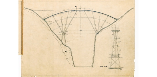 Ausführungsplan des Lehrgerüsts für die 1925 erstellte Valtschielbrücke. Es handelt sich um die dritte versteifte Stabbogenbrücke des Bauingenieurs Robert Maillart. Weil die Lehrgerüste damals kostspielig waren, entwickelte er dieses statische System, in dem das hölzerne Gerüst den schlanken Betonbogen allein tragen muss. Im Endzustand wird der Bogen vom darüber liegenden Fahrbahnträger gegen Knicken ausgesteift – ein Novum in der Geschichte des Eisenbetonbaus.