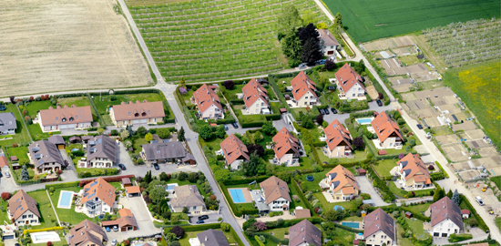 Wie viel zusätzliches Bauland muss in den nächsten 15 Jahren eingezont werden? Wie aus der nationalen Bauzonenstatistik hervorgeht, verfügen viele Orte über ausreichende und sogar überschüssige Reserven. (Das Luftbild zeigt einen Teil der Gemeinde Etoy VD.)