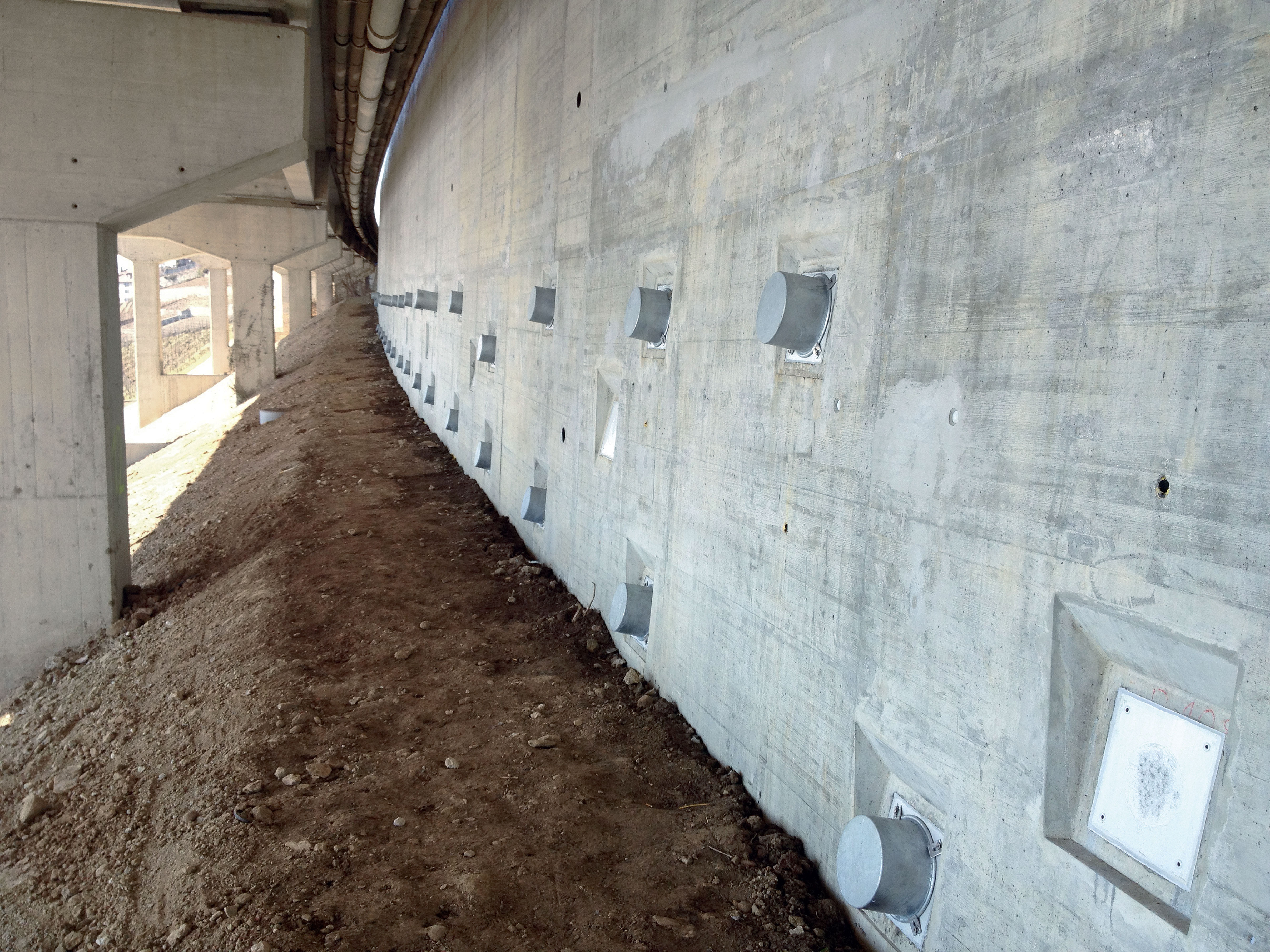 A9 – Les Curnilles : renforcement d’un mur aval à semelle avec un nouveau parement en béton armé ancré activement. Travaux exécutés dans un gabarit restreint - présence d’un pont