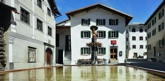 Der Dorfplatz mi dem umgebauten Eingihuus und dem grössten hölzernen Brunnen Europas bilden das neu belebte Herzstück von Valendas. (Foto: Ralph Feiner)