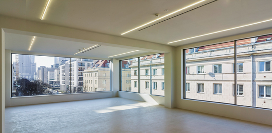 Ausstellungsebene im 3.OG: Die Betontragstruktur blieb erhalten und trägt die neue Fassade; die Heizung ist im neuen Anhydritboden integriert. Durch die grossen Fenster auf der Ost- und Südseite schweift der Blick in die ulica Górskiego mit ihrer neotraditionalistischen Architektur der 1940er- und 1950er-Jahre.