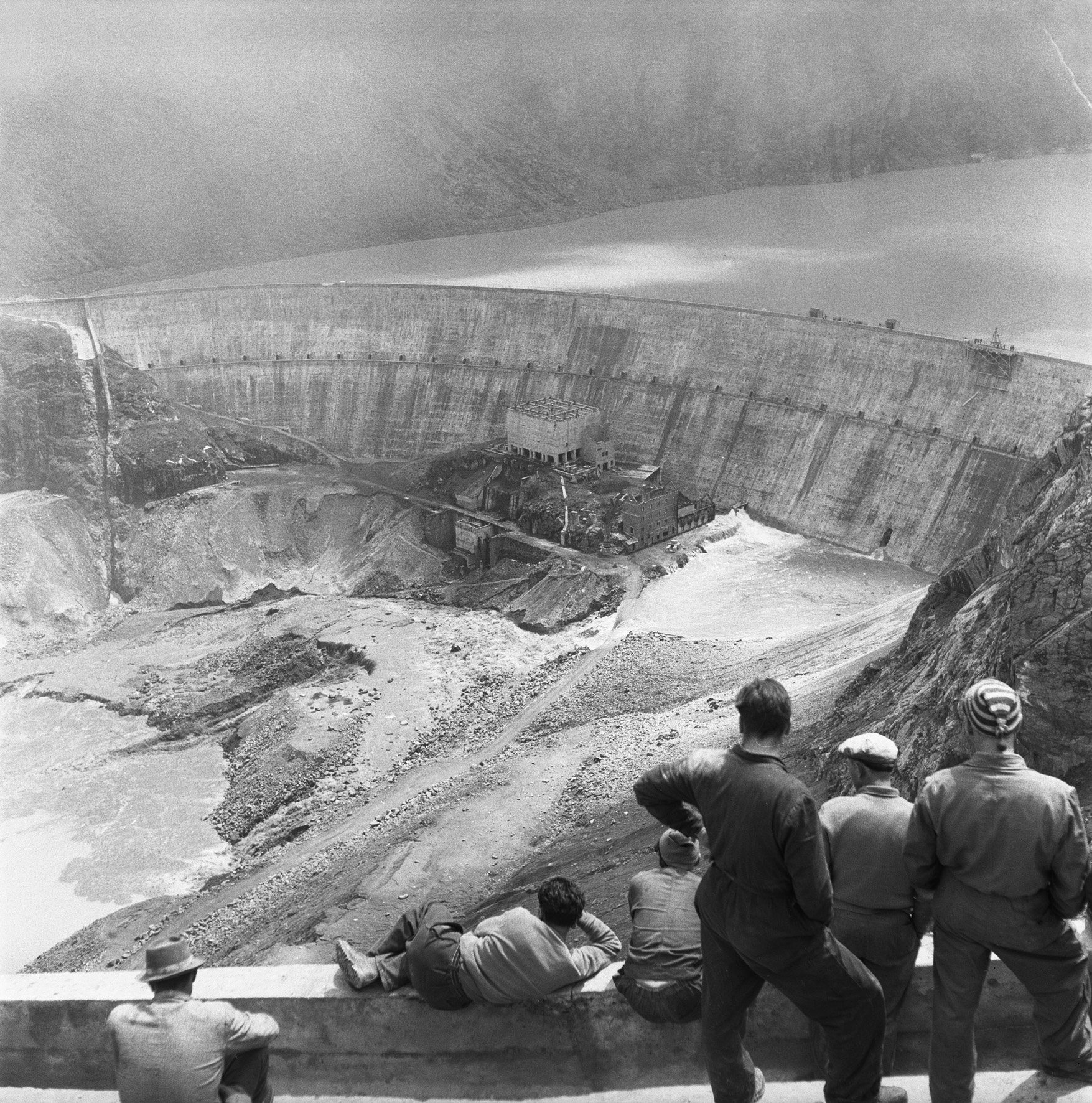 Beginn des Aufstauens auf der Baustelle der Staumauer Grande Dixence im Kanton Wallis, aufgenommen am 17. Juli 1957 (im Bild die alte Staumauer «Première Dixence», die später unter dem Wasserspiegel liegen wird)