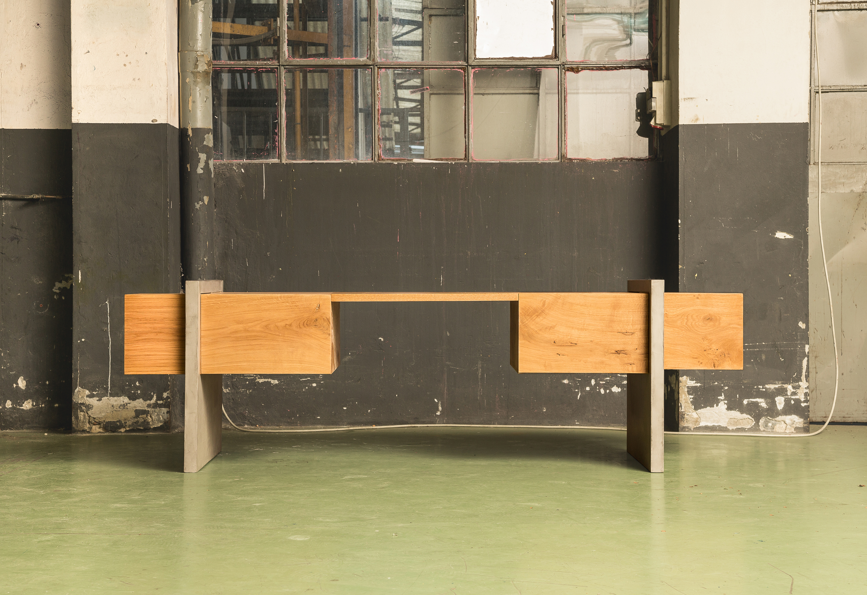 Der 2.5m lange Schreibtisch besteht aus zwei Betonsockeln mit zwei eingeschobenen, quer liegenden und balkenförmigen Elementen, die Schubladen und Stauraum enthalten. (Foto:Delfino Sisto Legnani)