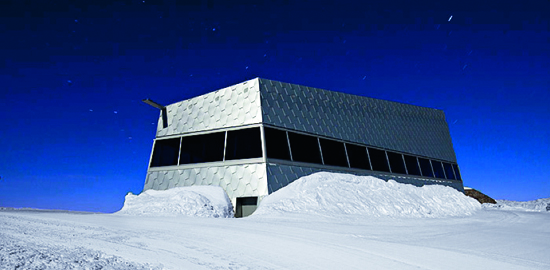 Die Fassade aus natureloxierten Aluminiumschindeln umhüllt den sechseckigen Kubus. Ein umlaufendes Fensterband ermöglicht einen 360°-Rundblick