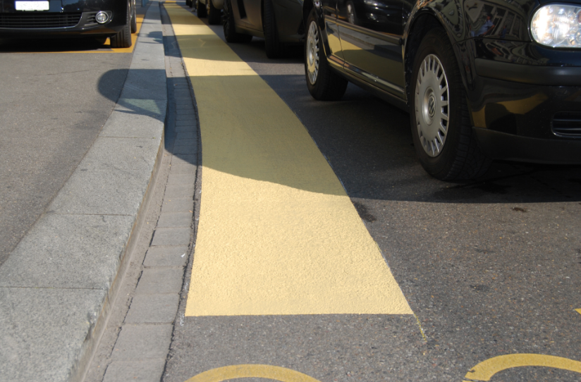 Hellgelbe Strassenmarkierung in Zürich.