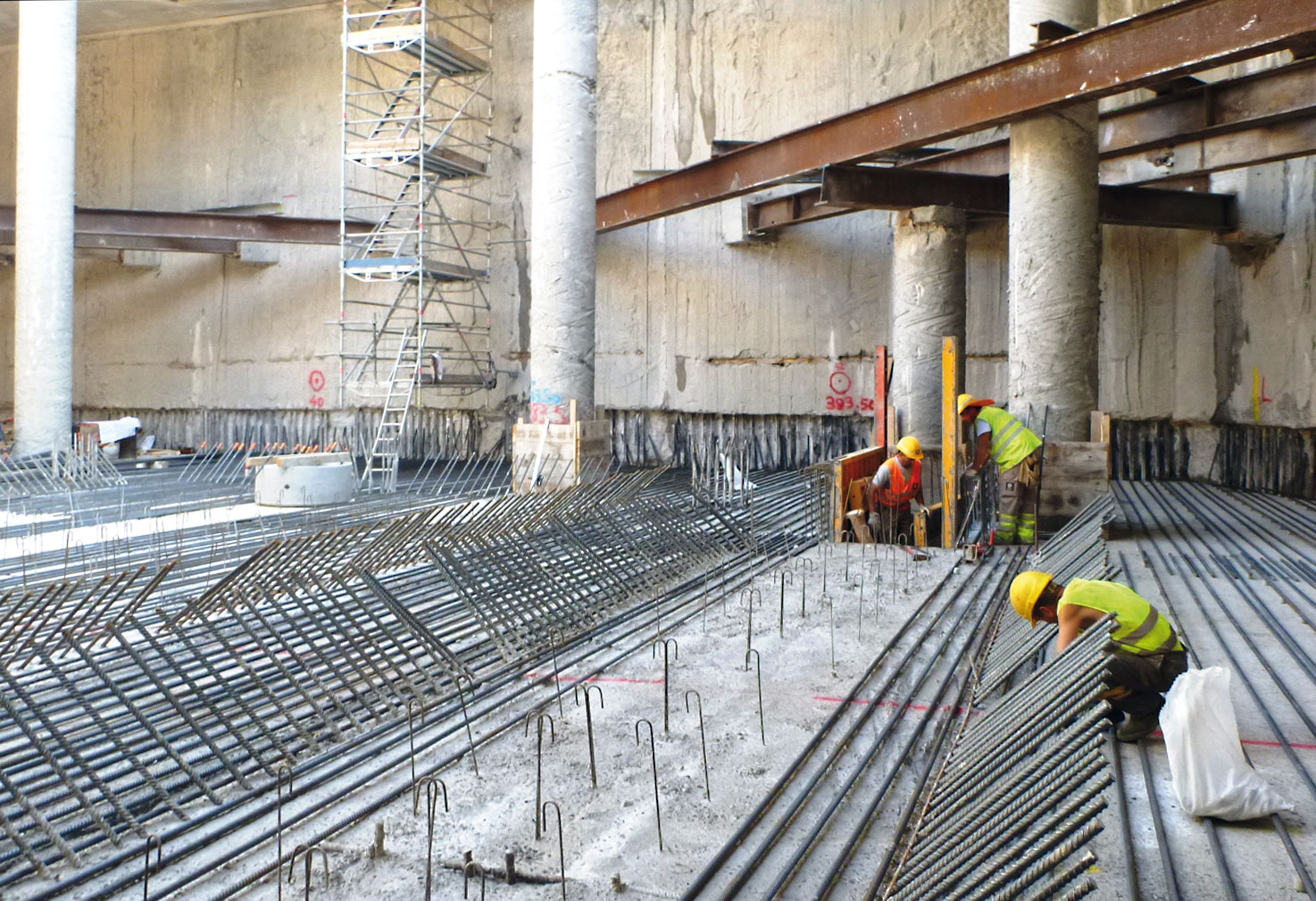 Ferraillage du radier. On voit aussi les pieux provisoires en béton et l’étayage horizontal provisoire entre la dalle mezzanine et le radier.