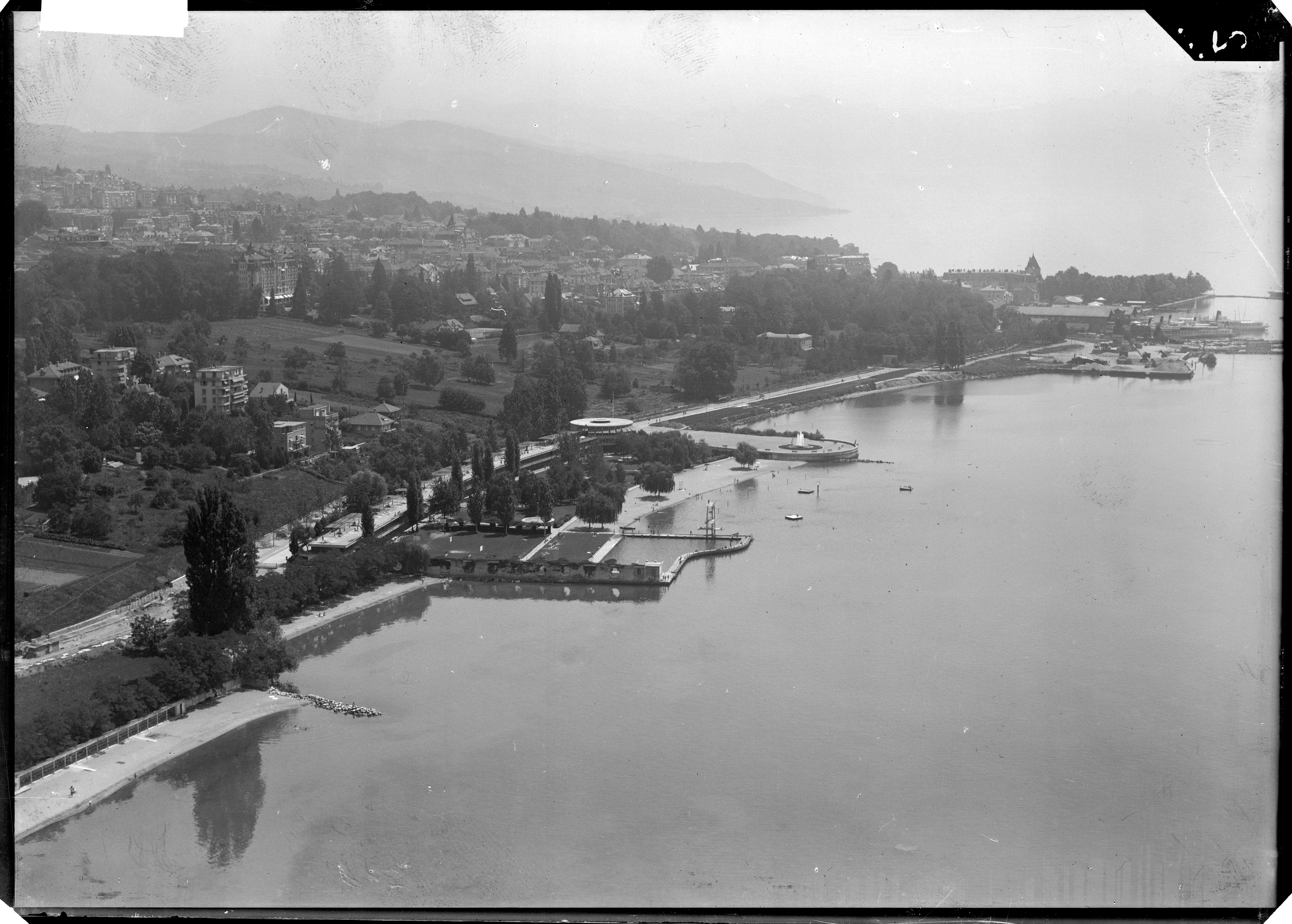 Vue aérienne depuis le sud-ouest vers 1940. La nouvelle plage de Bellerive s’avance dans le lac, avec son bassin à l’ouest et l’esplanade avec jet d’eau à l’est.