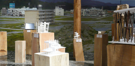 Tapissant les murs, des photos de la commune de Rikuzentakata après le tsunami qui a frappé l’île de Honshu en 2011 encadrent les maquettes et esquisses des habitations projetées, réparties dans la salle