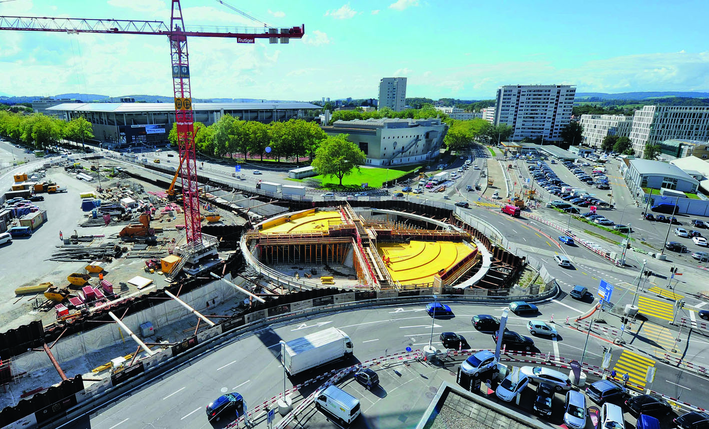 Zwei sich in der Mitte kreuzende, vorgespannte Träger bilden die Haupttragelemente der Kreiseldecke. Sie verbinden das Kreisel­zentrum und die Aussenwände miteinander. Der helle Druckring aus Stahlbeton dient als Abstützung der Spundwände